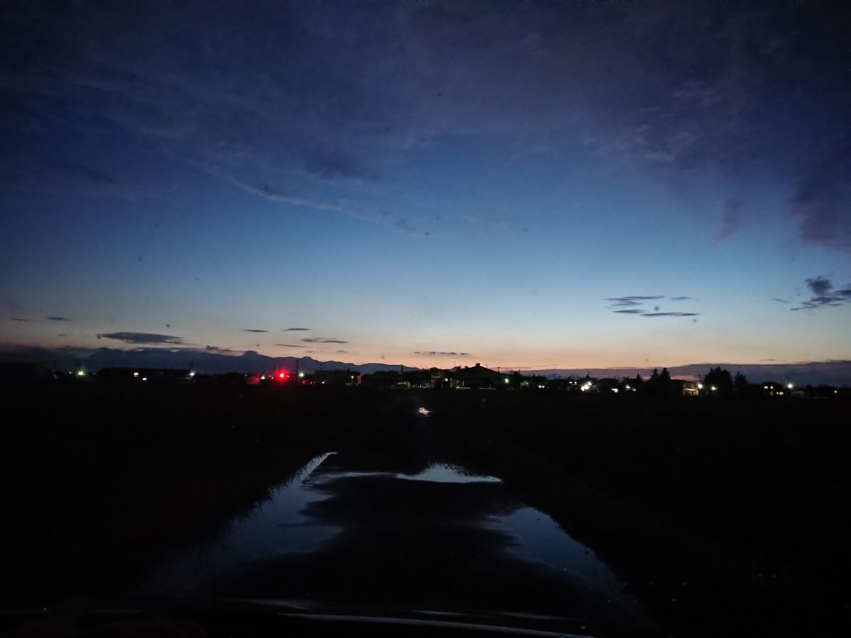 一本道から西の空 闇夜に光る水たまり