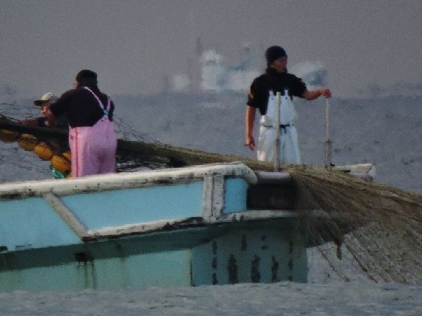 網を曳く若者「冬の海」